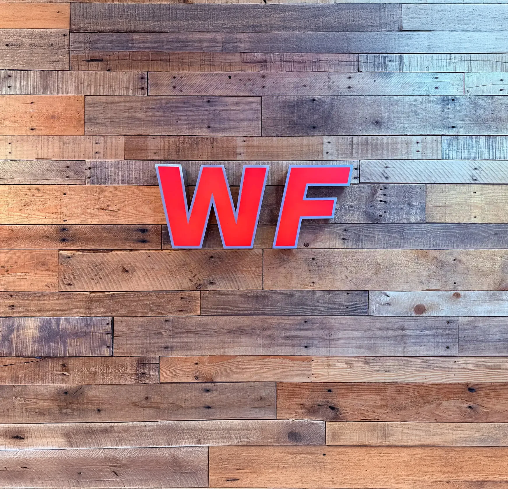 Picture of the inside of the WF office, vintage skateboard decks hanging on the wall with a modern sofa in the foregorund.