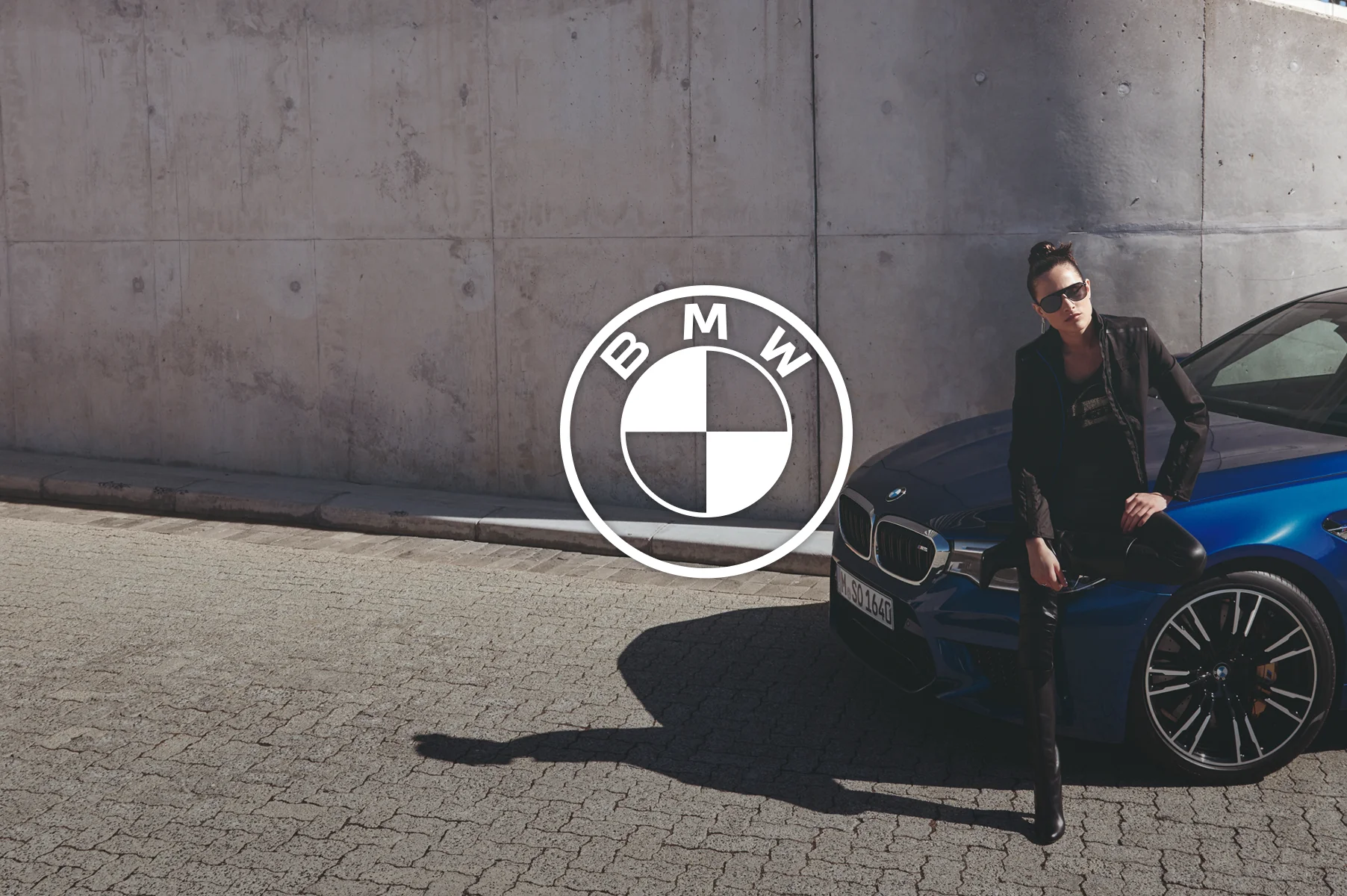 Woman posing on the hood of a BMW car
